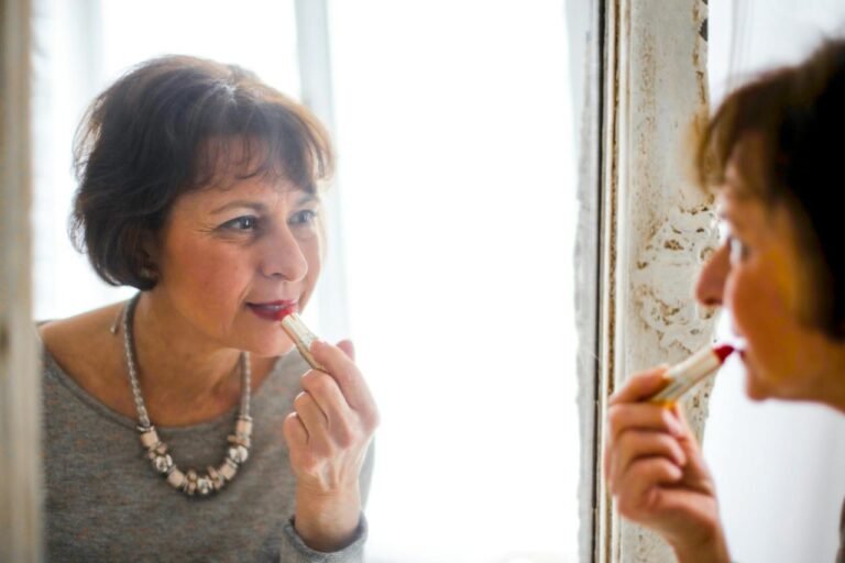 mature woman putting on make up