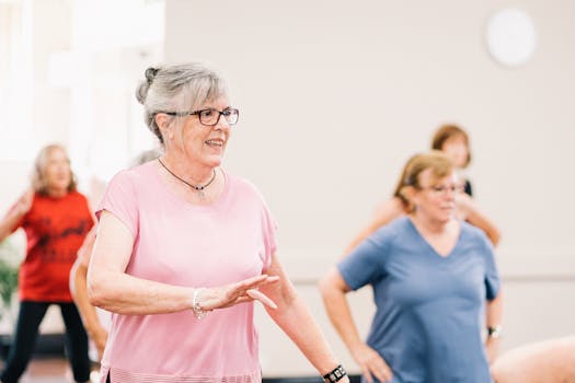 Senior women participating in a lively and joyful group exercise session indoors.