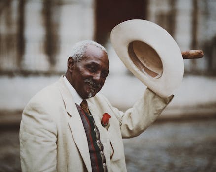 Capture of a distinguished senior man in suit holding a hat, exuding elegance.