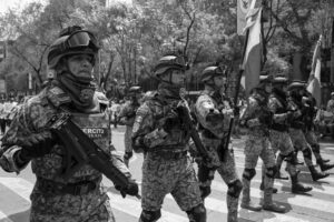 Mexican army soldiers marching in a military parade outdoors.