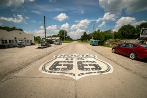 Quintessential Route 66 view featuring classic Americana town and vintage cars under blue skies.