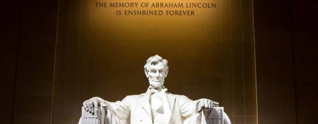 Illuminated Lincoln Memorial statue with engraved quote, Washington D.C.