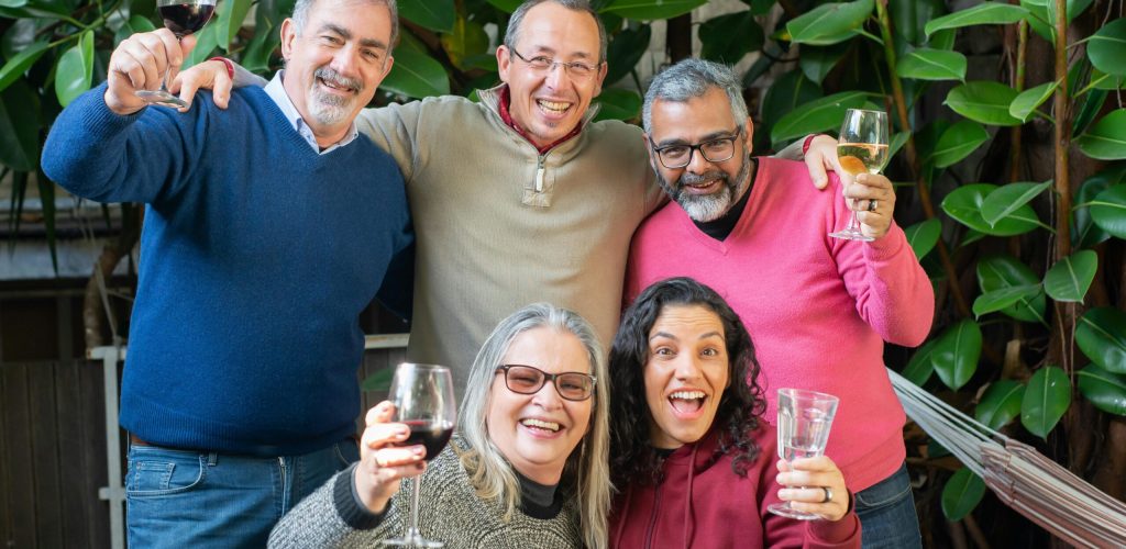 pexels-photo-6950690-6950690 Happy group of friends smiling and toasting with wine in a lush outdoor setting.