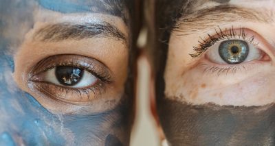 Closeup portrait of two women with facial masks, highlighting diversity and skincare routines.